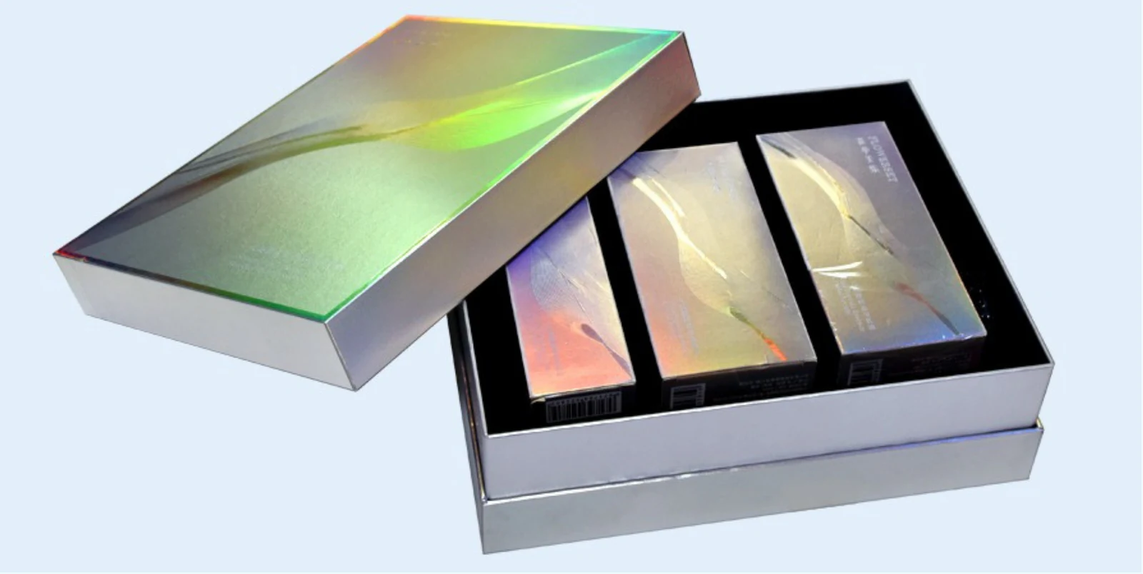 Caja plateada con acabado iridiscente y tres productos en su interior